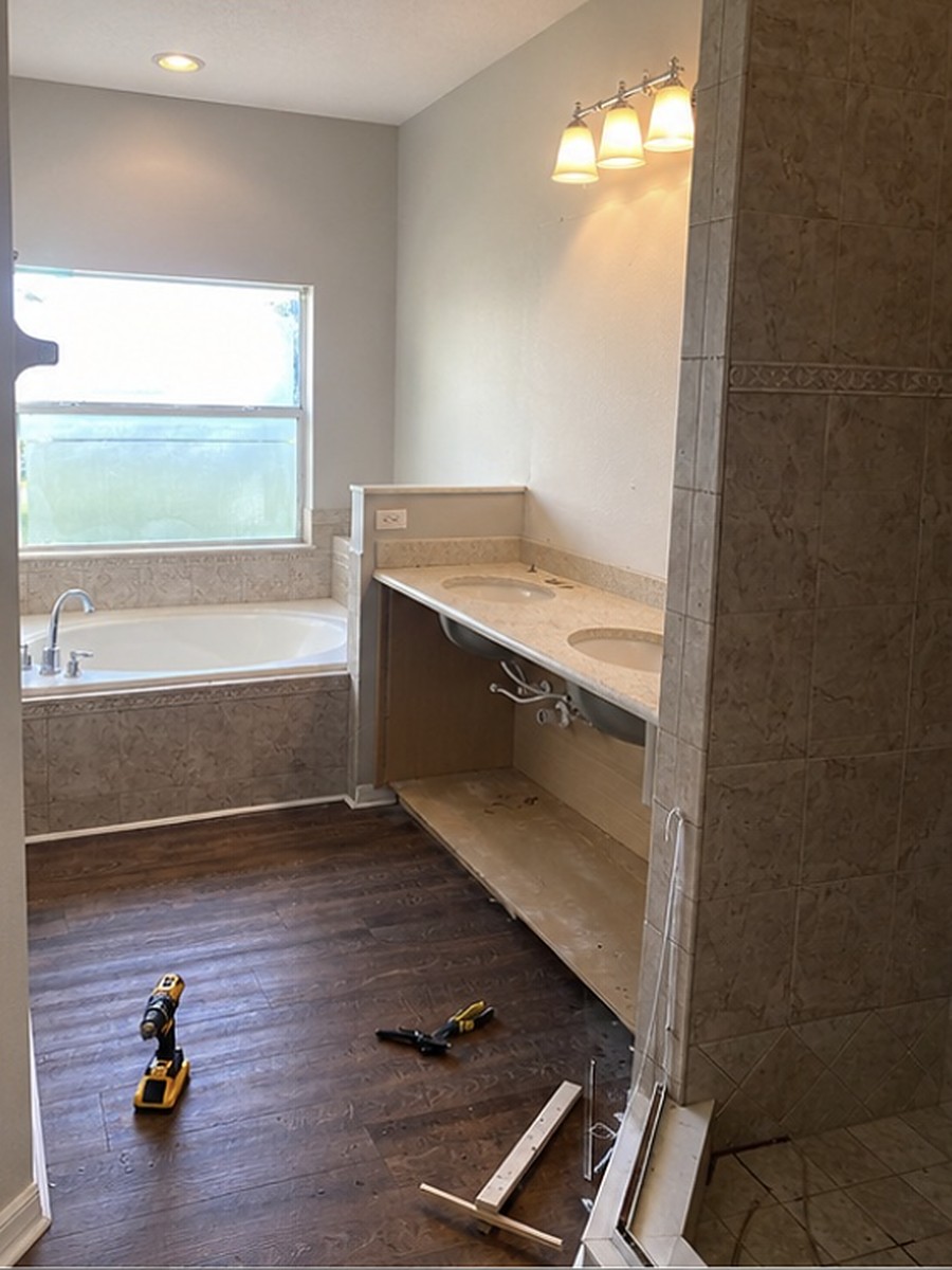 Master bathroom mid demolition with the old garden tub, tiled wall and vanity removed