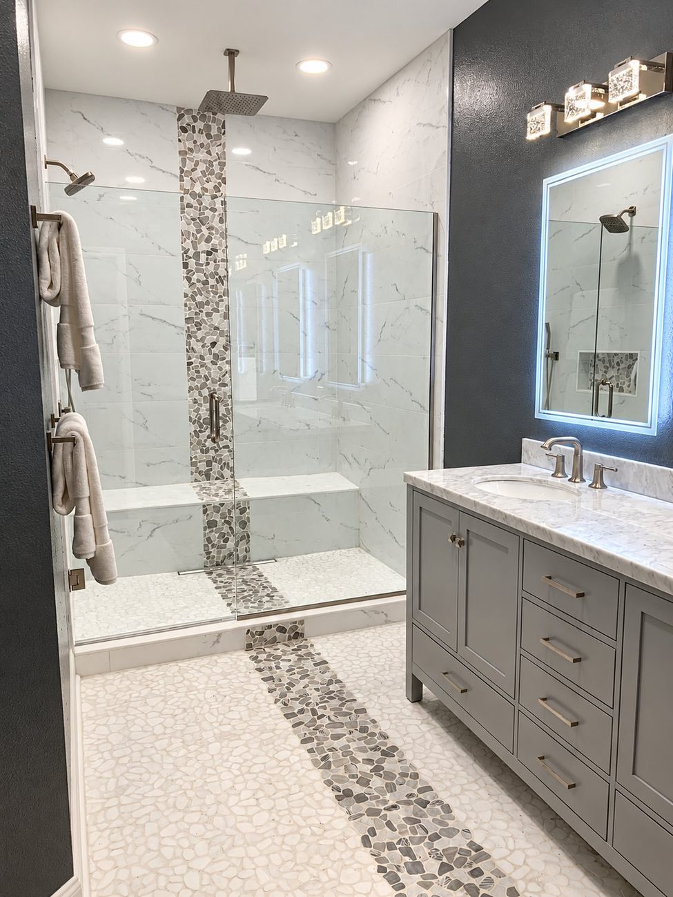 Walk-in shower with built-in tiled bench and continuous pebble mosaic inlay