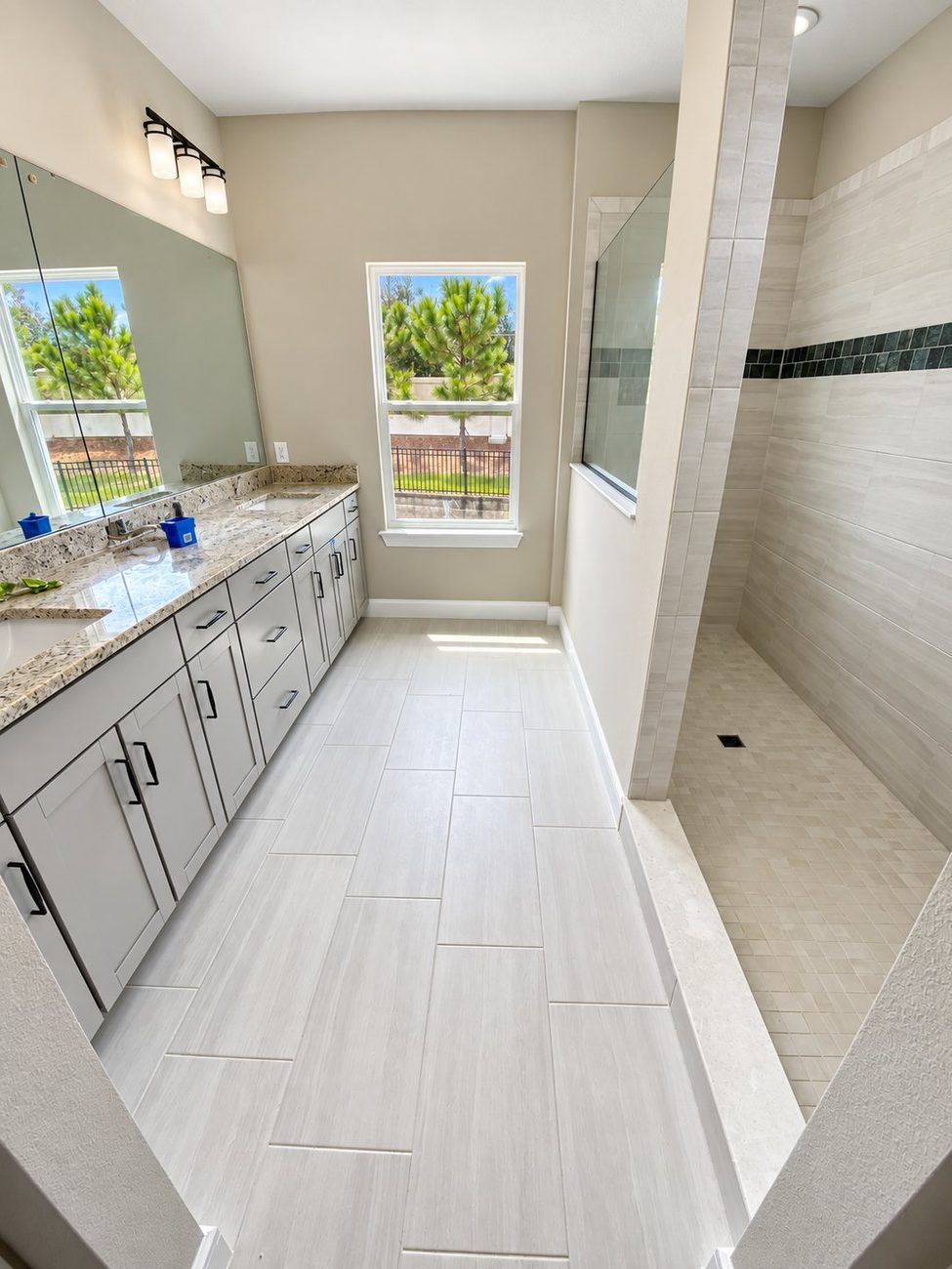 Bathroom with double granite vanity and doorless walk-in shower