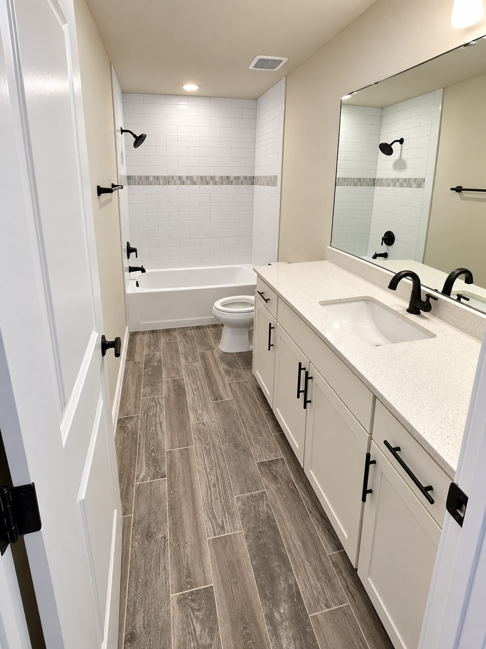 Alcove tub with subway tile surround, glass mosaic accent band and matte black fixtures