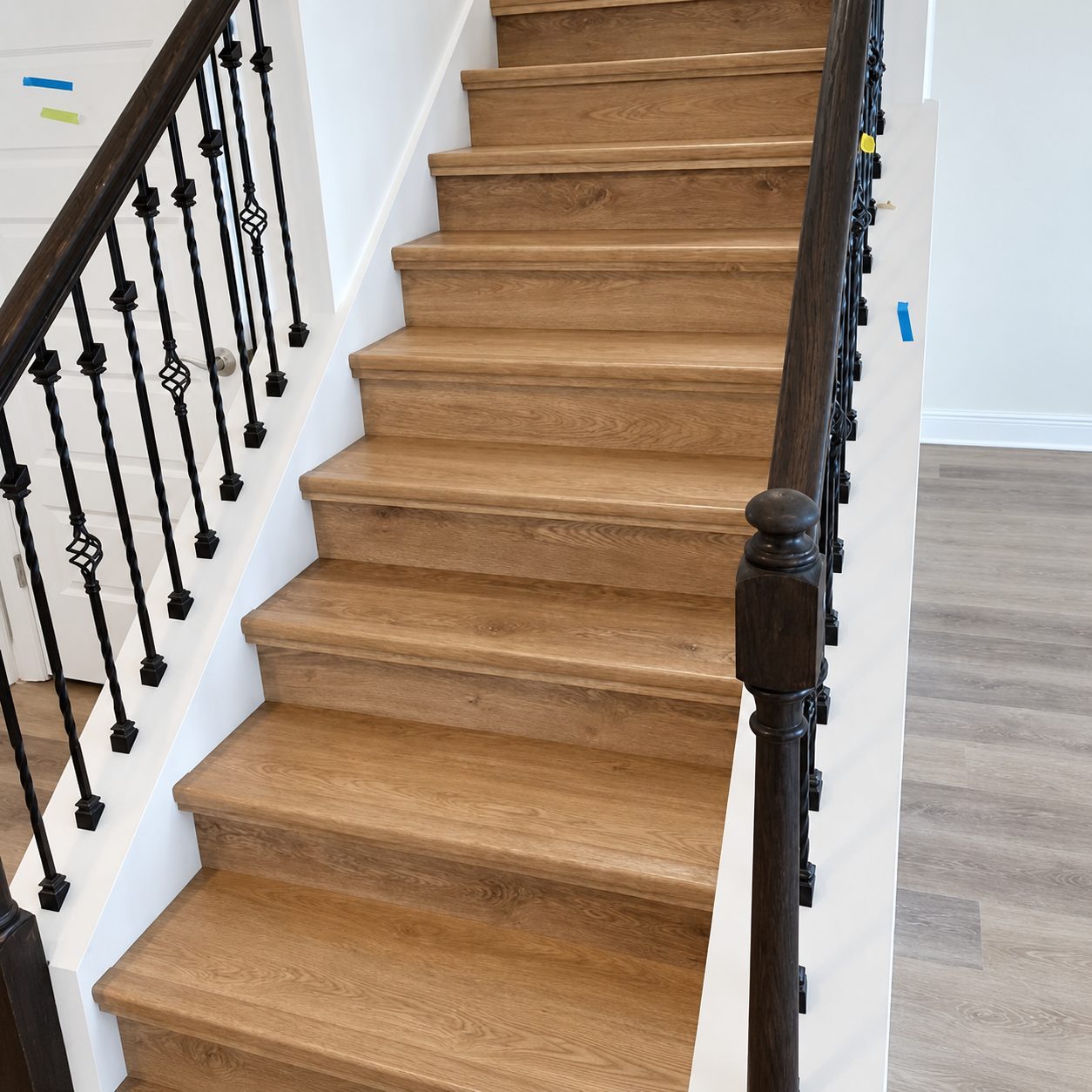 Oak stair treads and risers with a dark stained handrail and iron balusters