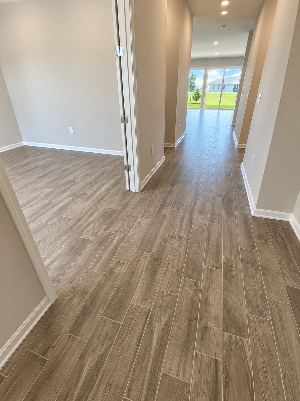 Wood-look porcelain plank carried from the entry hall through to the living area and slider