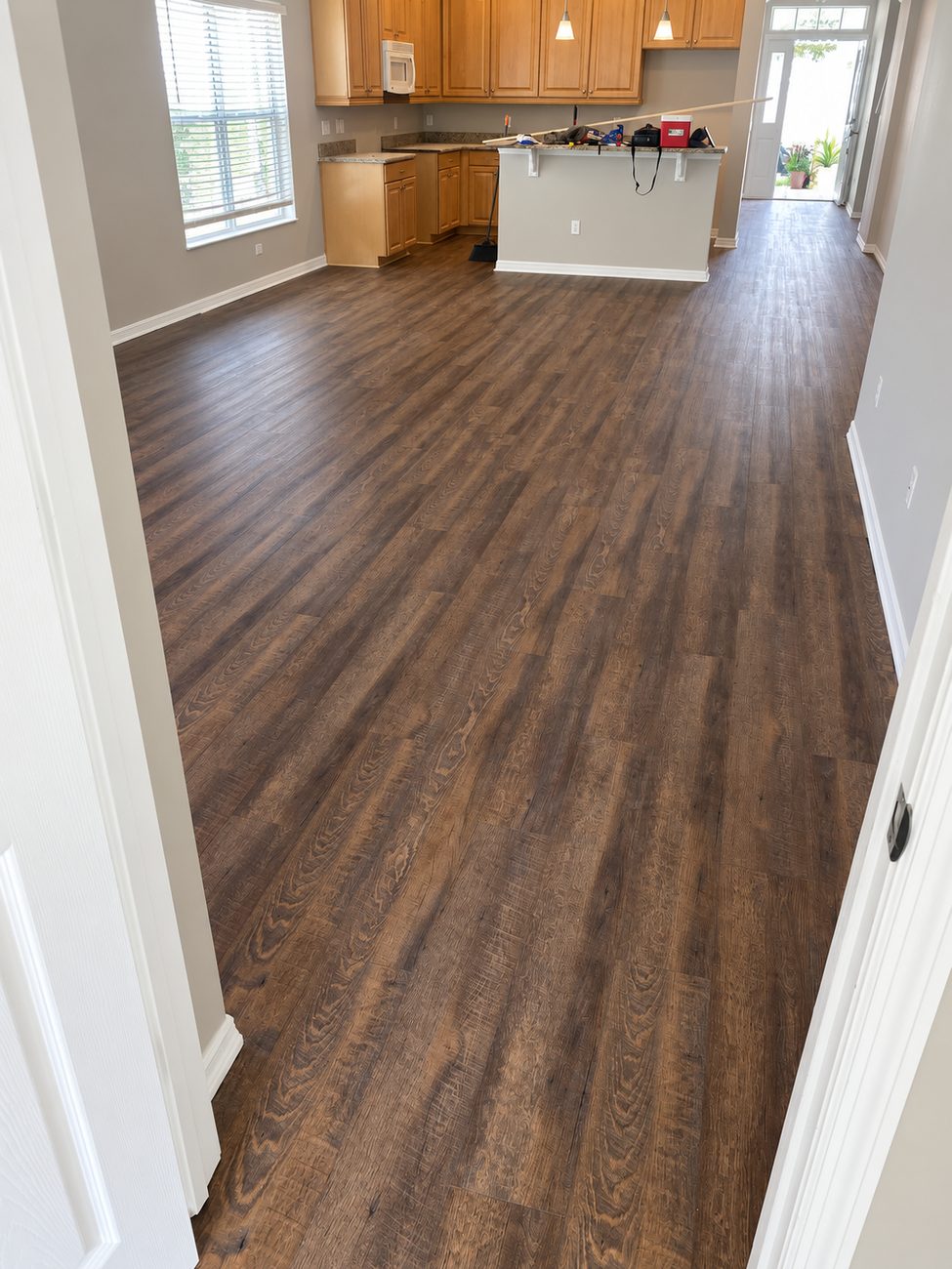 Dark rustic oak plank flooring laid through an open living and dining area