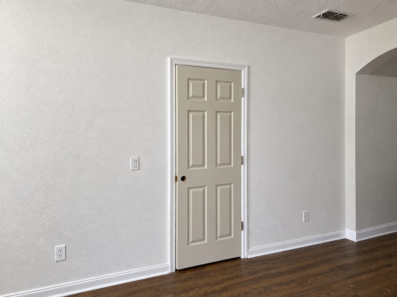 Finished and primed drywall wall with a door and casing installed